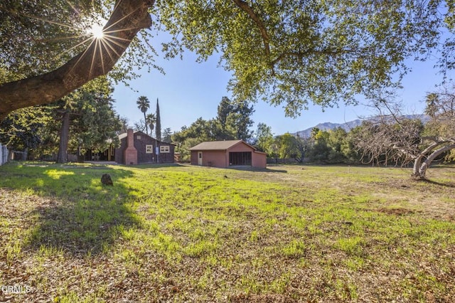 view of yard featuring an outbuilding, a pole building, and a mountain view