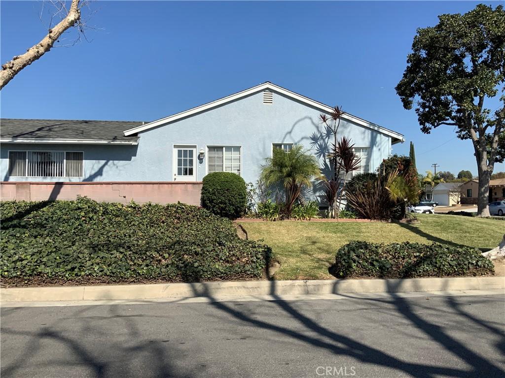 view of side of home with stucco siding and a yard