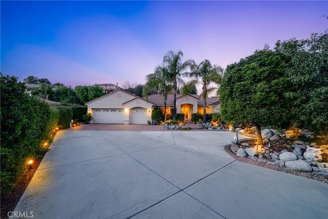 mediterranean / spanish-style home featuring an attached garage and concrete driveway