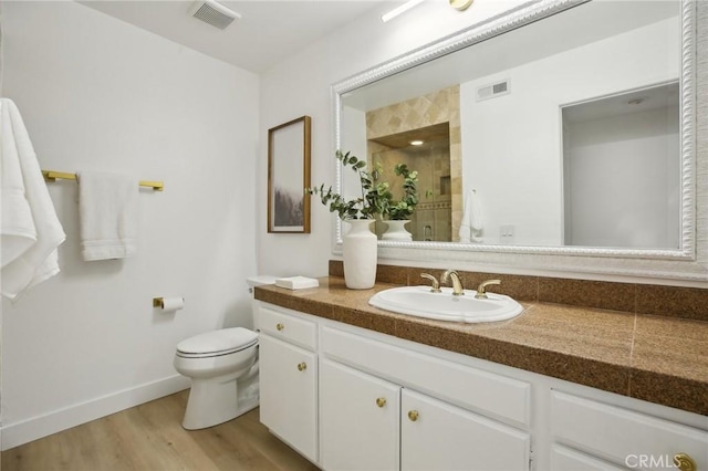 bathroom featuring visible vents, a shower stall, toilet, and wood finished floors