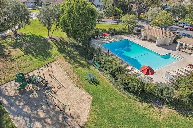 community pool featuring a patio area, fence, playground community, and a yard