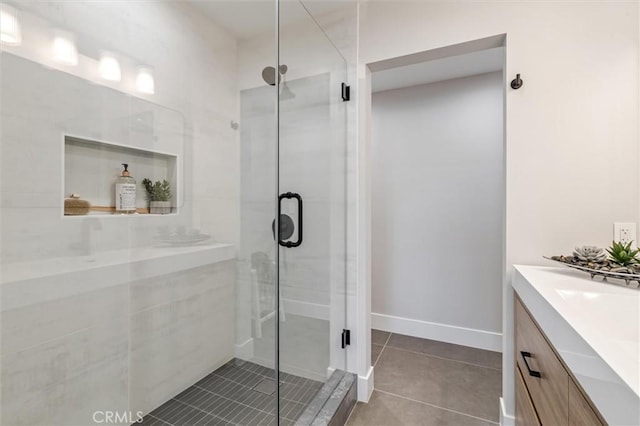 bathroom with tile patterned flooring, a shower stall, and vanity