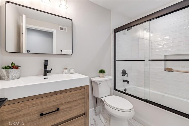 full bathroom featuring toilet, visible vents, combined bath / shower with glass door, and vanity