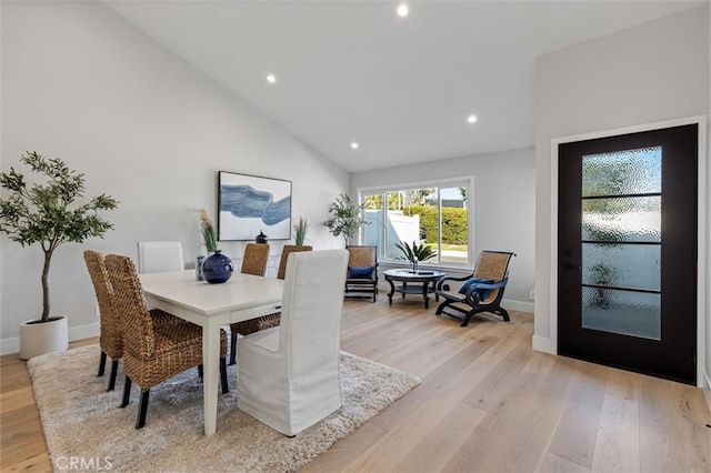 dining area featuring baseboards, high vaulted ceiling, light wood-type flooring, and recessed lighting