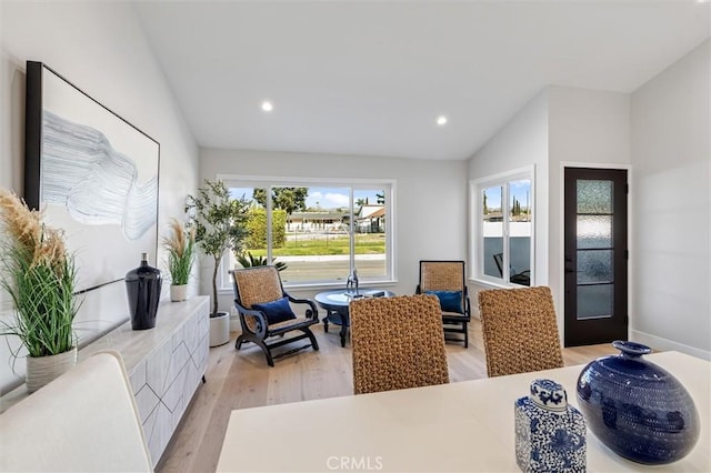 dining space with light wood-style flooring, vaulted ceiling, and recessed lighting