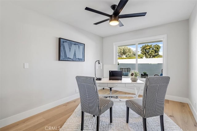 home office featuring light wood-style flooring, baseboards, and ceiling fan