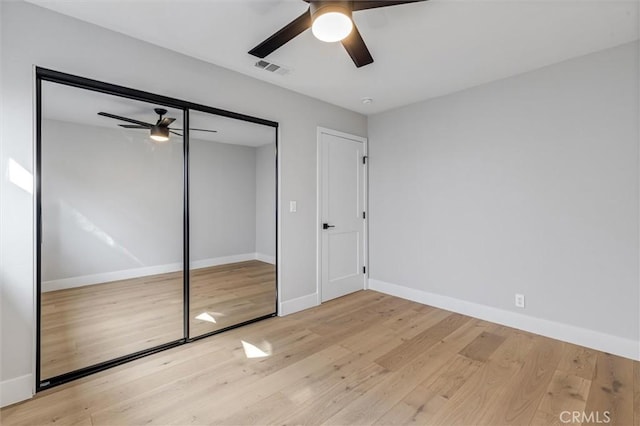 unfurnished bedroom with a ceiling fan, wood finished floors, visible vents, and baseboards