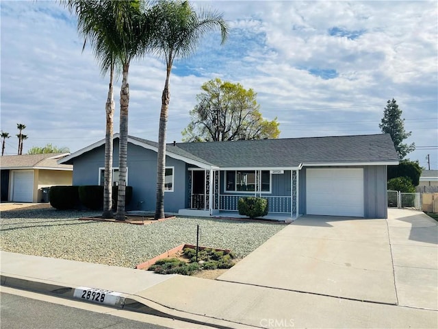 single story home with a porch, an attached garage, fence, driveway, and roof with shingles