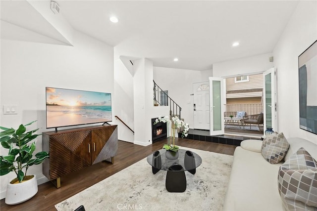 living room featuring baseboards, stairway, wood finished floors, a fireplace, and recessed lighting