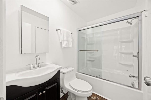 bathroom with toilet, combined bath / shower with glass door, vanity, and visible vents