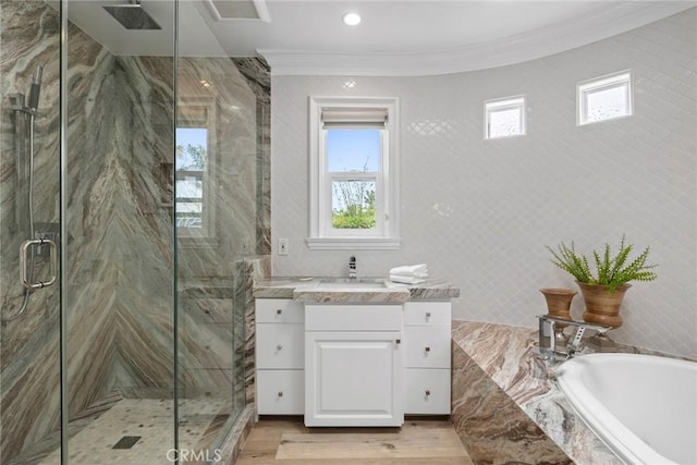 full bathroom featuring a garden tub, crown molding, a marble finish shower, vanity, and wood finished floors