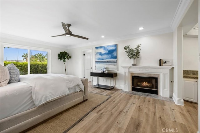 bedroom with ornamental molding, light wood-type flooring, a high end fireplace, and recessed lighting