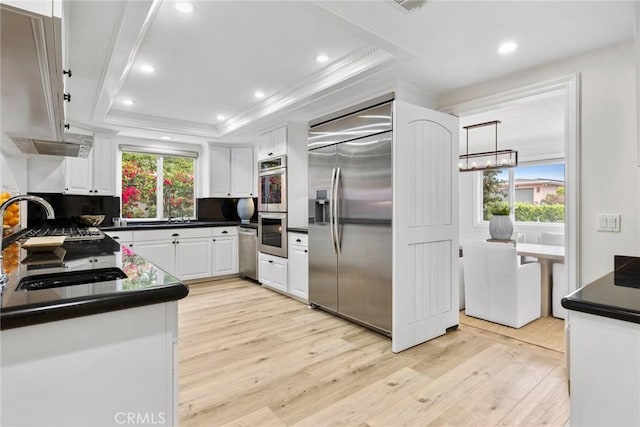 kitchen featuring appliances with stainless steel finishes, a tray ceiling, white cabinets, and dark countertops