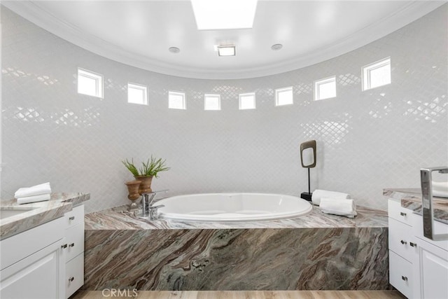 bathroom featuring a garden tub, crown molding, and vanity