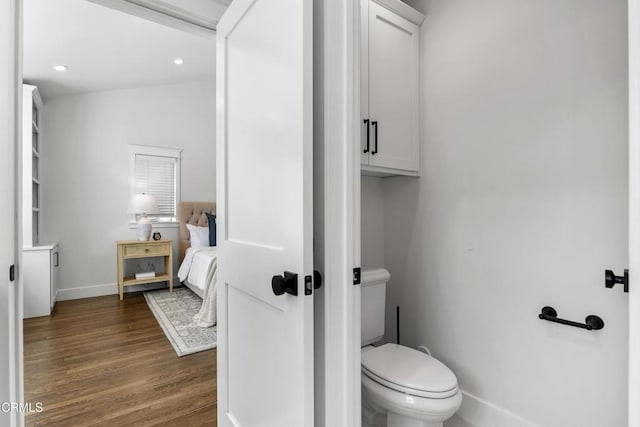 bathroom featuring toilet, baseboards, wood finished floors, and recessed lighting