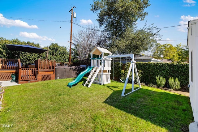 view of play area with a deck and a yard