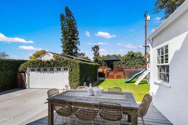 exterior space featuring an outbuilding, outdoor dining area, a playground, a garage, and fence