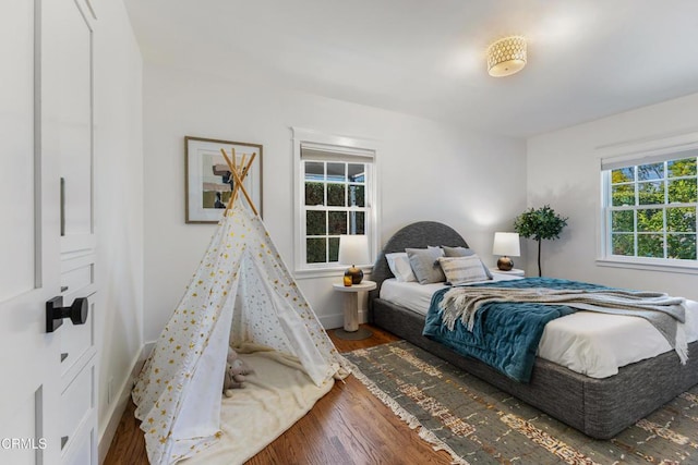 bedroom with baseboards and wood finished floors