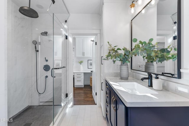 bathroom featuring a stall shower, vanity, and wood finished floors