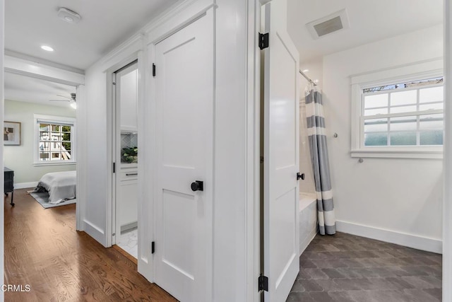 hall featuring dark wood-style floors, recessed lighting, visible vents, and baseboards