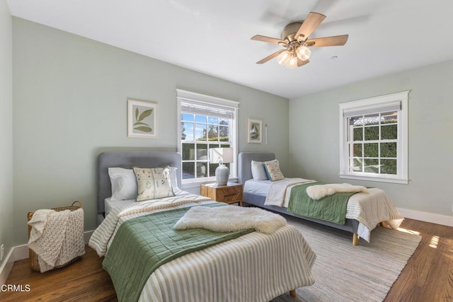 bedroom with ceiling fan, baseboards, and wood finished floors