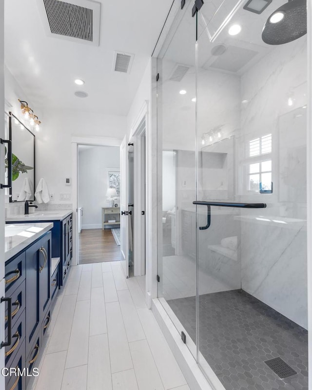 bathroom with a stall shower, visible vents, vanity, and recessed lighting