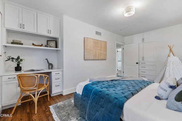 bedroom with dark wood-style floors, visible vents, and baseboards