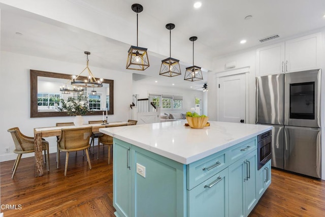 kitchen featuring a center island, visible vents, appliances with stainless steel finishes, dark wood-type flooring, and blue cabinets