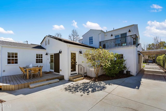 back of property featuring outdoor dining area, a wooden deck, and stucco siding