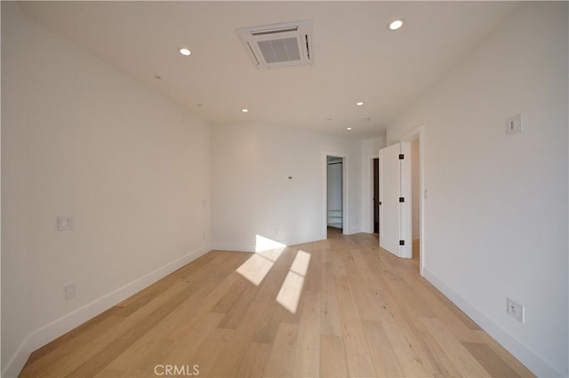 spare room featuring light wood-style floors, recessed lighting, visible vents, and baseboards