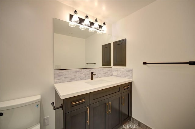 bathroom featuring tasteful backsplash, vanity, and toilet