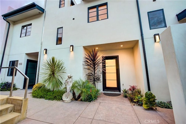 view of exterior entry featuring stucco siding