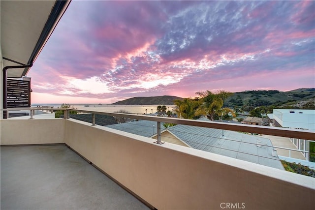 balcony at dusk featuring a mountain view