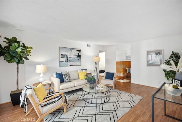 living room featuring visible vents and wood finished floors