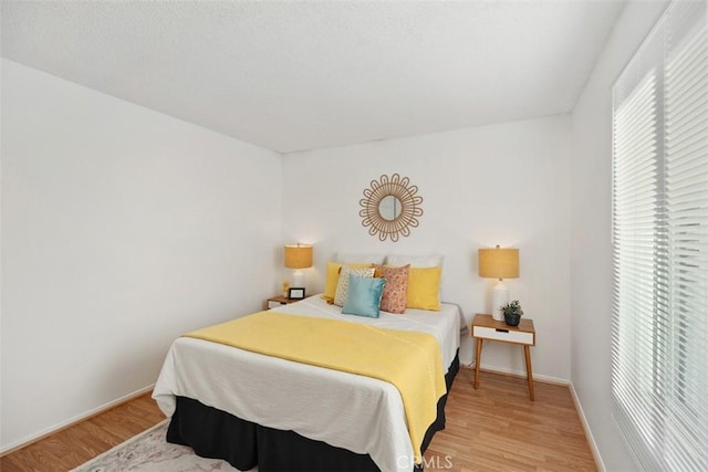 bedroom featuring light wood-style floors and baseboards