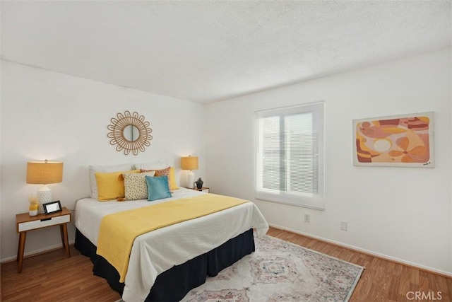 bedroom featuring wood finished floors and baseboards