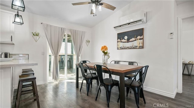 dining room with baseboards, a ceiling fan, a wall unit AC, dark wood-style floors, and vaulted ceiling