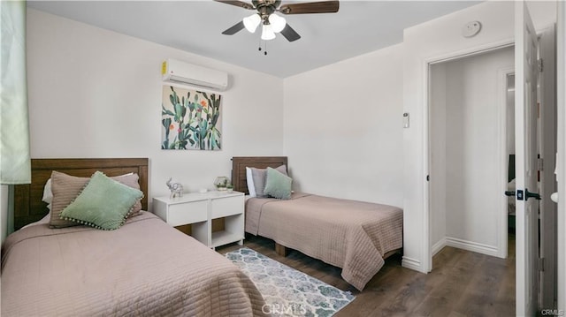 bedroom featuring an AC wall unit, a ceiling fan, baseboards, and wood finished floors