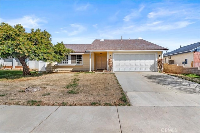 single story home featuring concrete driveway, an attached garage, and fence