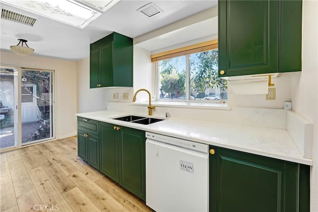 kitchen with light wood-style flooring, a sink, visible vents, green cabinets, and dishwasher