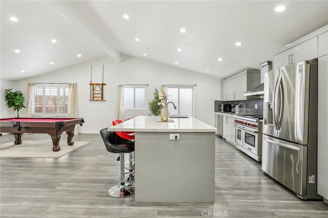 kitchen featuring a center island with sink, stainless steel appliances, light countertops, a sink, and modern cabinets