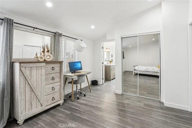 home office featuring baseboards, vaulted ceiling, wood finished floors, and recessed lighting