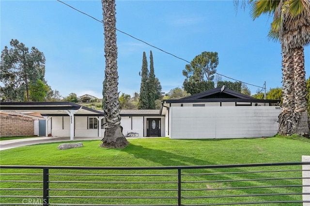 mid-century inspired home with a carport, a front yard, and fence