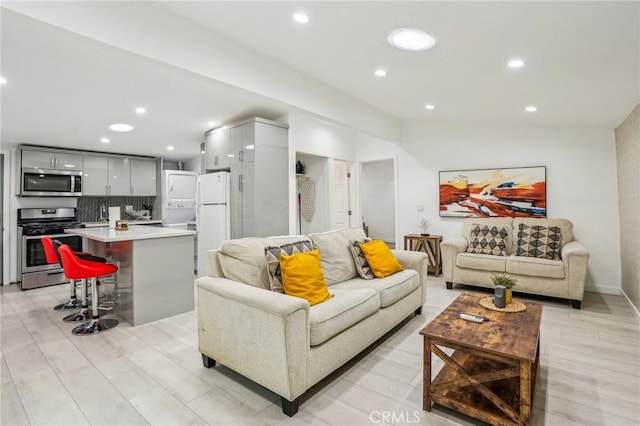 living area featuring lofted ceiling, light wood-style flooring, and recessed lighting