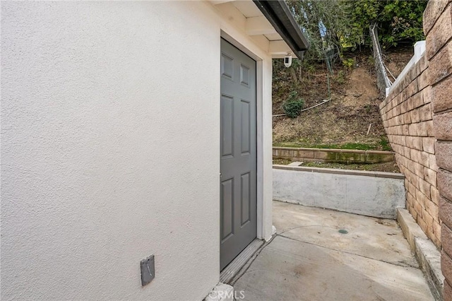 doorway to property featuring stucco siding