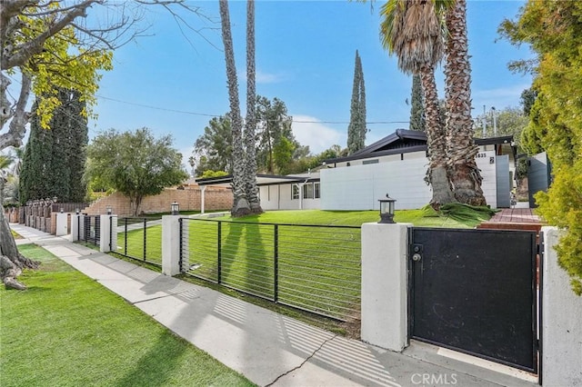 view of yard with a fenced front yard and a gate