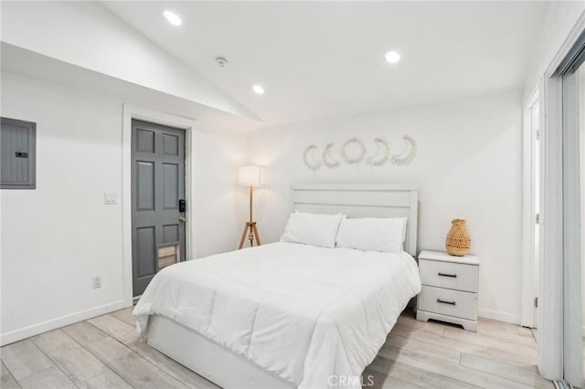 bedroom featuring lofted ceiling, light wood-type flooring, electric panel, and recessed lighting