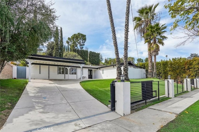 mid-century inspired home with a fenced front yard, driveway, and a front lawn