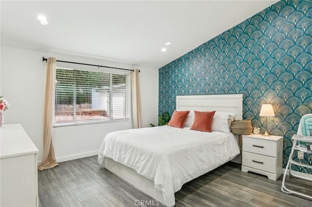 bedroom with wallpapered walls, an accent wall, and baseboards