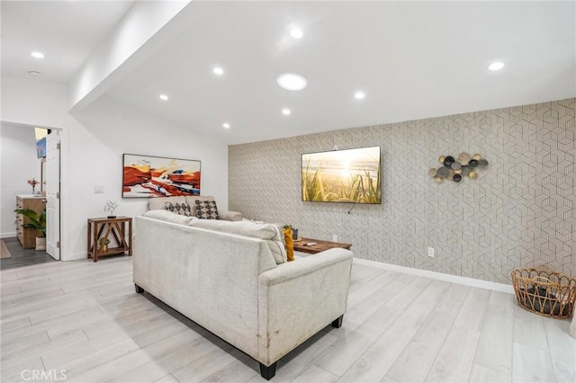 living room featuring light wood-style flooring, recessed lighting, baseboards, vaulted ceiling, and wallpapered walls